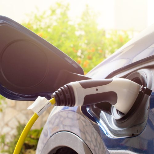 The electric car charger plugged in to the socket.The modern electric car charging the battery.